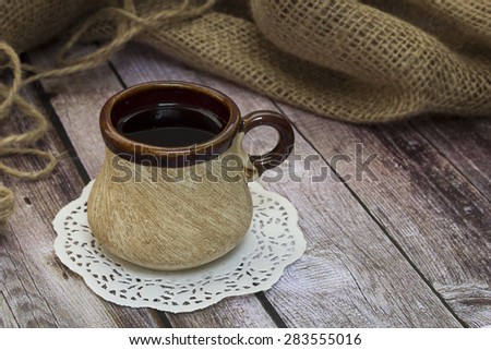 tea in an old mug on a light table near burlap