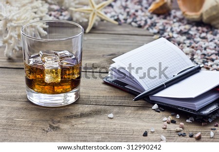 whiskey with a notebook among the sea of stones on the table