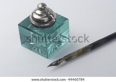 Inkpot with pen on white background