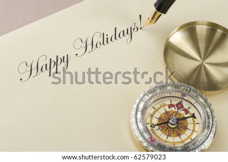 Inscription Happy Holidays with gold pen and compass