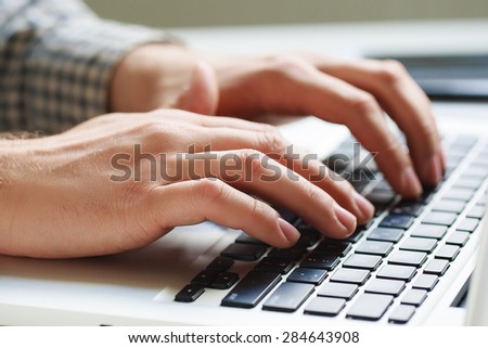 Office man hand on laptop keyboard