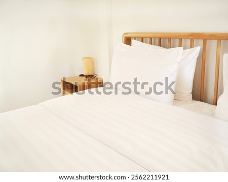 Similar – Foto Bild Das Bett ist mit sauberen weißen Kissen und Bettwäsche im Zimmer ausgestattet.