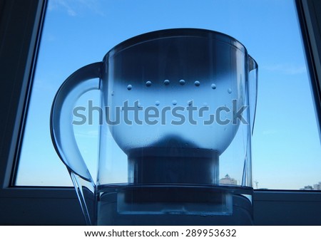 Water filter with clear water at kitchen windowsill