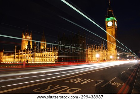 Big Ben and Westminster Abbey at night with traffic rushing passed/ Big Ben and Westminster Abbey at night