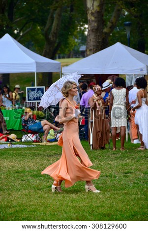 Jazz Age Lawn Party/ Jazz Party New York/ New York, USA - August 16, 2015: Lady walking at the lawn enjoying music at the Jazz Age Lawn Party in New York, dressed up in 1920 style. at governors island