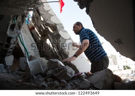 GAZA, PALESTINIAN TERRITORY - DECEMBER 3: A government employee searches for documents amid the rubble of the Palestinian National Authority Council of Ministers building, December 3, 2012.