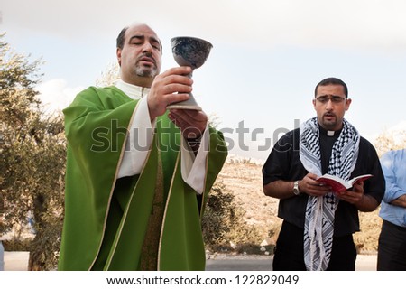BEIT JALA, PALESTINIAN TERRITORY - OCTOBER 5: A Palestinian Catholic priest serves communion during a mass protesting the Israeli separation wall in Beit Jala, West Bank, Oct. 5, 2012.