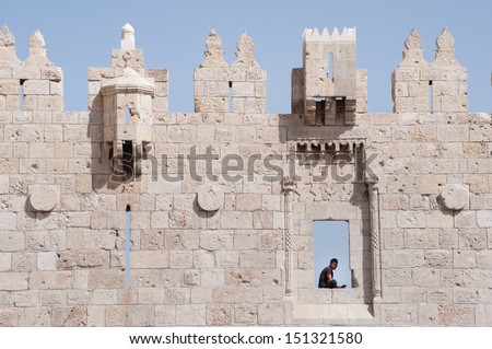 JERUSALEM - JUNE 7: A Palestinian youth sits in a window above the Damascus Gate to the Old City of Jerusalem, June 7, 2013.