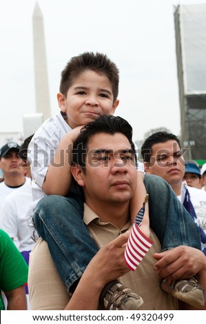 WASHINGTON, DC - MARCH 21: A boy on his father\'s shoulders stands with some 200,000 immigrants\' rights activists flood the National Mall to demand comprehensive immigration reform on March 21, 2010 in Washington DC.