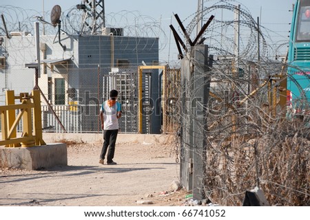JAYYOUS, OCCUPIED PALESTINIAN TERRITORIES - NOVEMBER 2: A Palestinian youth waits to pass through a checkpoint in the Israeli separation barrier on Nov. 2, 2010 in JAYYOUS.