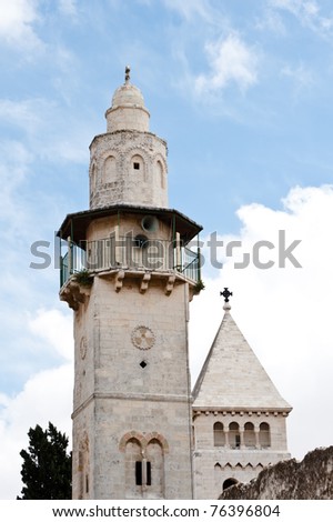 The minaret of the Mosque of Omar rises above the Old City of Jerusalem next to the steeple of the Lutheran Church of the Redeemer.