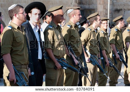 JERUSALEM - AUGUST 24: A visitor to Western Wall stands with ranks of the Israeli Army\'s Marva program, which brings foreign Jews to receive military training, at the Western Wall on Aug. 24, 2011.