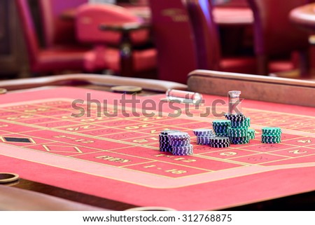 Casino American Roulette gambling table with a playing chips on the layout.