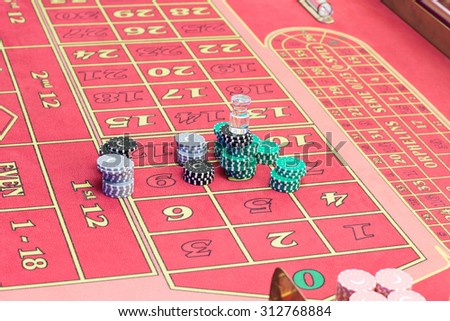 Casino American Roulette gambling table with a playing chips on the layout.