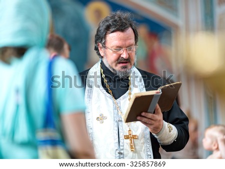 KLAIPEDA, LITHUANIA - 09 AUGUST 2014: Christening in the Russian orthodox church. Pope is dressed in the holy attire and doing sacred rite. Klaipeda city, LIthuania.