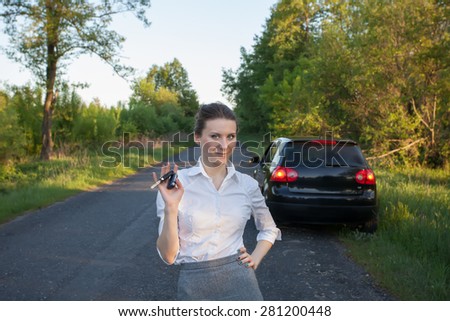 Beautiful business girl with car key in hand