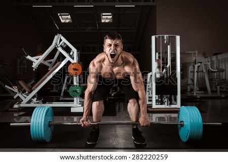 Muscular Man Lifting Deadlift In The Gym