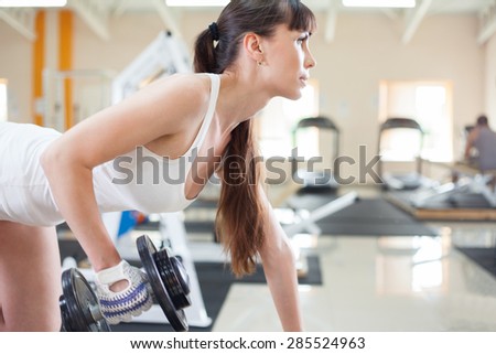 Female fitness girl exercising indoor in fitness center.