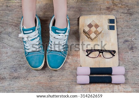 office wooden table with chopping board and glasses, memory card, and sneaker, top view