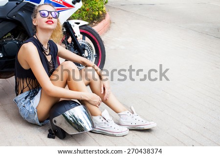Fashionable sensual blonde on city street. Trendy urban Look. Motor style,cool and fashion ,wear motorcycle helmet and stylish Sunglasses.