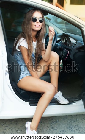 Young business woman sitting in car,wear bright summer denim suit,natural lifestyle colors,life portrait girl in summer round black sunglasses,natural beauty,summer clothes,city lifestyle denim suit