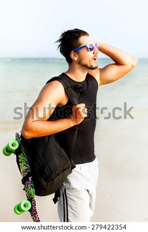 closeup portrait of a young casual man looking away from the camera.Posing opposite the sea side at sunshine,enjoying beautiful view and relax near ocean.hiker,sportsman,Hipster style guy, sunset
