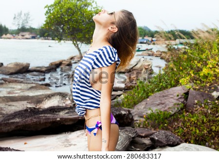 Happy carefree woman in pink bikini on sand beach vacation holidays,freedom and relaxation concept.Look up to sky.Exotic european girl wearing a summer clothes on the beach,bikini,summer sunglasses