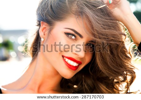 Outdoor fashion portrait of glamour lady with perfect make-up and glowing skin,full red lips,and big eyes posing at sunset,tan model face.Sexy perfect fit body woman.Attractive sexy and young girl