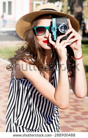 Young sexy smiling photographer woman,holding and making picture on retro vintage camera,wearing swag straw bright cap,amazing view on the european city,joy and happiness.vintage camera,jewelry store