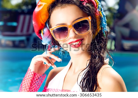 Outdoor fashion portrait of glamour lady enjoying her vacation on luxury villa over the pool,wet hair,stylish sunglasses,bikini.perfect nail polish.Summer accessory,sunglasses fashion,flash tattoo