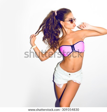 Stylish fashionable girl hipster with lolly pop in casual teen clothes.White background.Summer vibes,sunglasses fashion,girl in pink clothes,fashion swagger outfit,play with ponytail.joy having fun