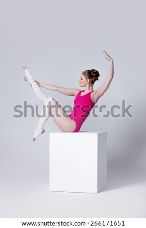 ballet dancer. attractive young woman gymnast on a white cube