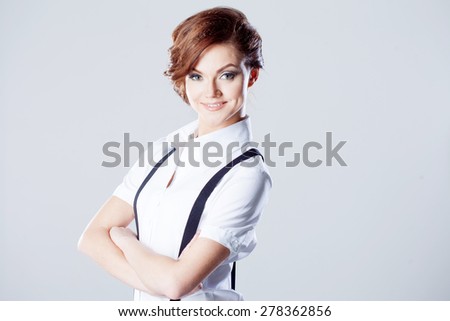 Successful business woman, in shirt on white background, pants with suspenders