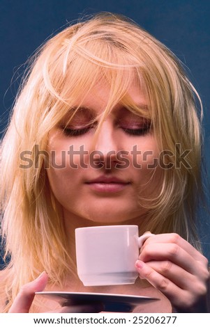 a beautiful girl breathes in the aroma of coffee