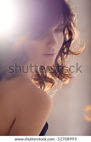 Light of beauty. Portrait of the elegant young girl in sun beams