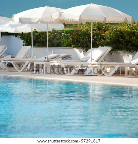 Plank beds with umbrellas at pool, hotel territory