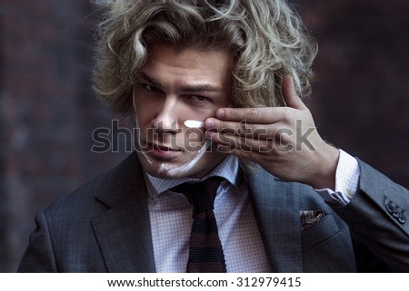 Businessman warrior. Young man makes war paint on his face, concept