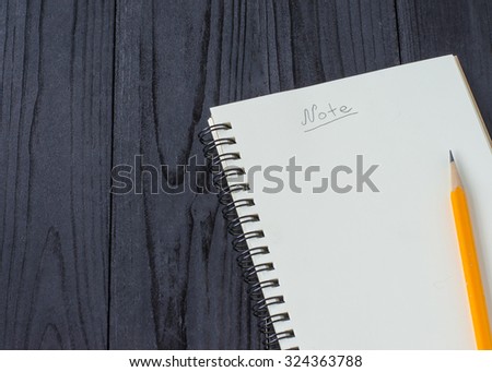 Note book and pencil on wooden