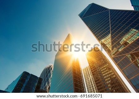 Skyscraper glass facades on a bright sunny day with sunbeams in the blue sky. Modern buildings in Paris business district La Defense. Economy, finances, business activity concept. Bottom up view Stock foto © 