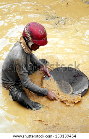BANG BO NANG CHING, SA KAEO, THAILAND - SEPTEMBER 16, 2011: A gold prospector sifts the soil tirelessly in the hope of finding a speck of gold, near Bang Bo Ching Nang, east Thailand.
