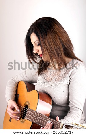 Studio shot of a woman holding guitar