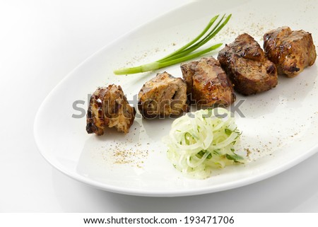 Appetizing stake with vegetables. Shish kebab isolated on white background