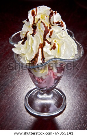 Fresh fruit in cream. A dessert from fruit and cream. Fruit with ice-cream and cream with chocolate topping.