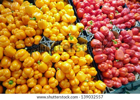 Cardboard boxes with orange and red bell peppers in supermarkets