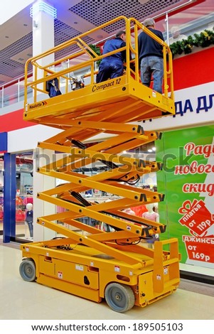 Tambov, Russian Federation - December 15, 2013: Electric Scissor Lift Haulotte Compact 12 works in supermarkets. The maximum load capacity of 300 kg.