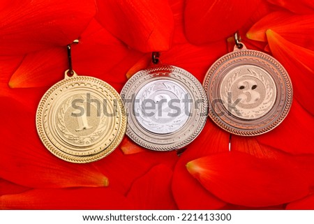 Sport medals (gold, silver and bronze) on red petals