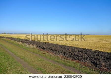 Field after harvest and the band plowed black earth