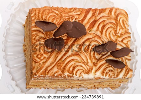 Layer cake with ground nuts on a white plastic plate