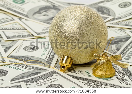 Gold decorative ball and bell on top of US paper currency