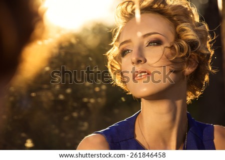 reflection of the young girl with blue eyes and in a blue dress in a mirror
